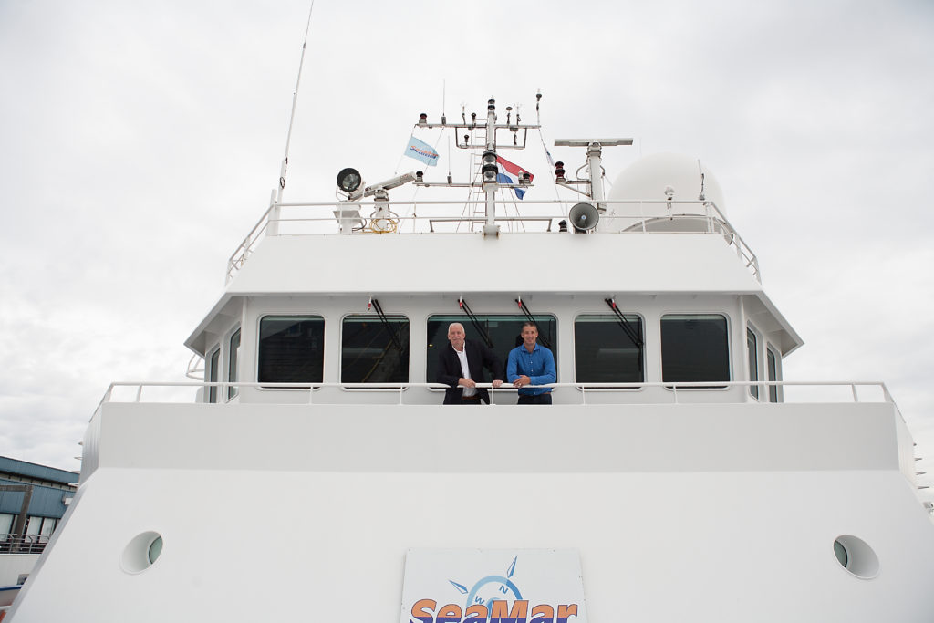 Foto van twee mannen die op de boot staan